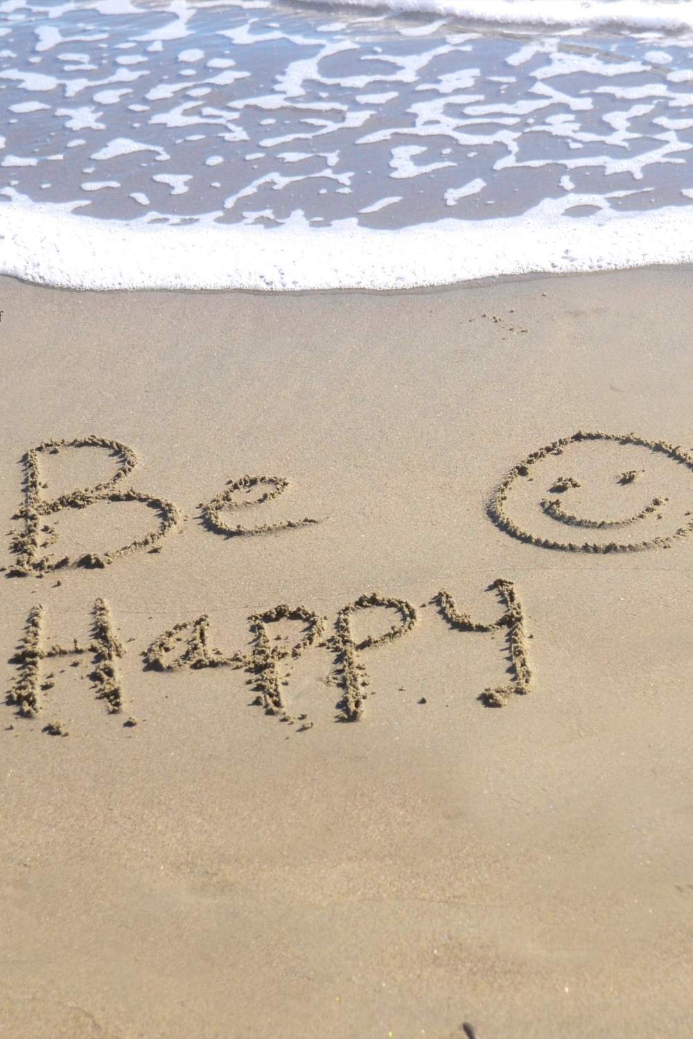 Be Happy written in the sand